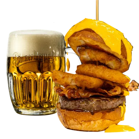 Hamburger con bacon croccante, anelli di cipolla e formaggio cheddar fuso accanto a un bicchiere di birra chiara Pilsner Urquell con schiuma
