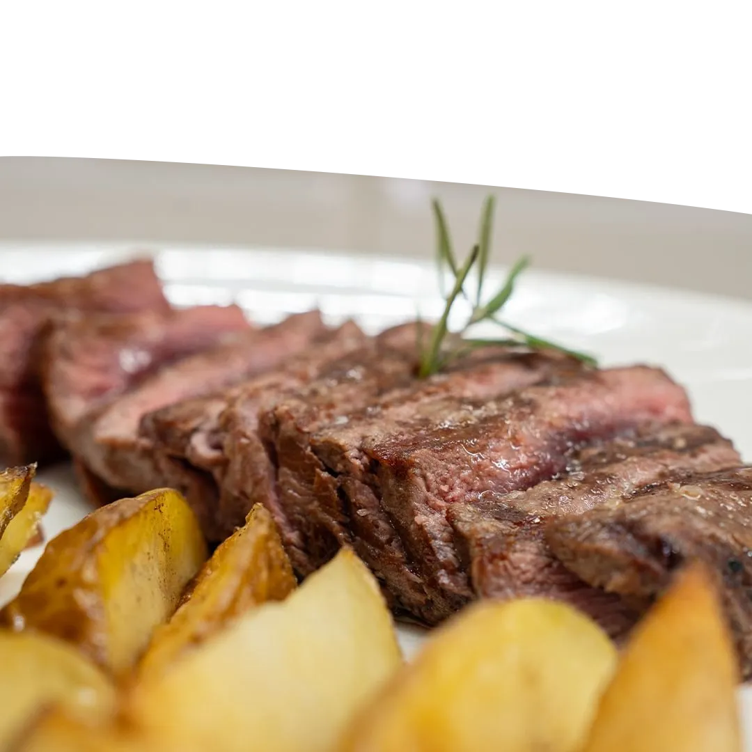 Tagliata di carne di manzo scottona cotta alla griglia servita a fette con patate al forno