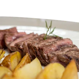 Tagliata di carne di manzo scottona cotta alla griglia servita a fette con patate al forno